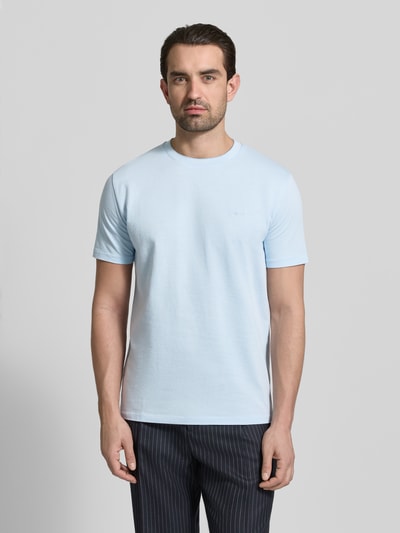 Männermodel trägt T-Shirt mit Rundhalsausschnitt und Label-Stitching von Gant, reine Baumwolle, Regular-Fit, hellblau, Ganzkörperansicht von vorne. Rückenlänge bei Größe M: 69 cm.