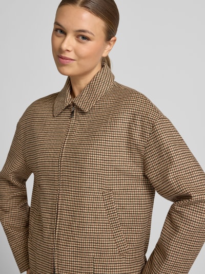 Frauenmodel trägt Jacke mit Reißverschluss Modell 'GINA' von Mango im Material-Mix mit Lanawoll-Anteil, Regular-Fit, Hemdblusenkragen, Reißverschluss und Eingrifftaschen, mehrfarbiges Karomuster, Nahaufnahme Oberkörper.