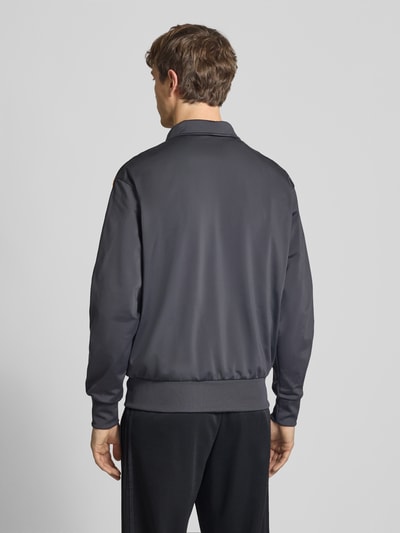 Männermodel trägt Regular Fit Trainingsjacke mit mehrfarbigen Kontraststreifen Modell 'FIREBIRD TT' von adidas Originals, Unifarbe, Ganzkörperansicht Rückansicht