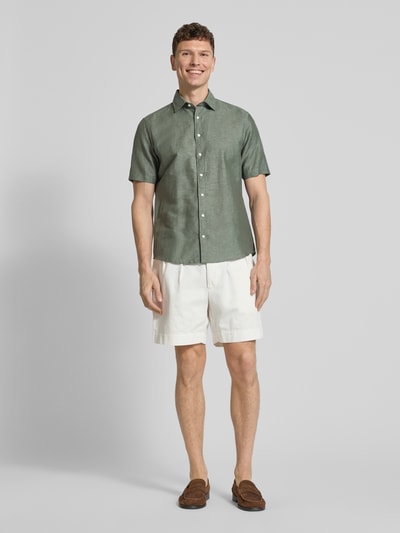 Männermodel trägt Slim Fit Freizeithemd aus Leinen-Mix von Jake*s in Grün, Kentkragen, kurze Ärmel, mit Knopfleiste, Ganzkörperansicht von vorne.