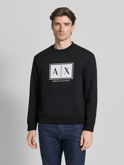 Mężczyznamodel nosi Sweatshirt mit Logo-Print und Rundhalsausschnitt von ARMANI EXCHANGE, czarny kolor, czysta bawełna, krój loose fit, nadruk z logo, okrągły dekolt, długość tyłu w rozmiarze M: 65 cm, długość rękawa w rozmiarze M: 61 cm, widok całej sylwetki z przodu.