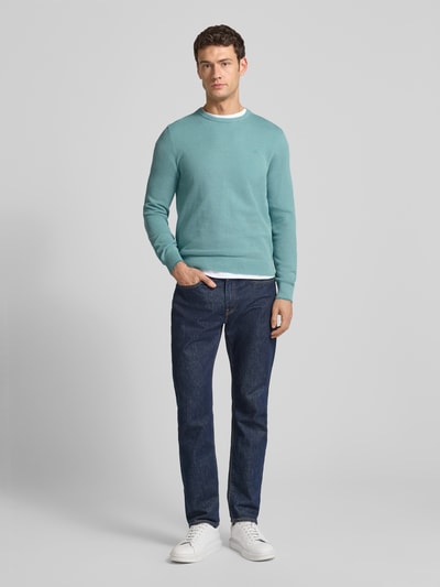 Męski model nosi Strickpullover mit Label-Stitching od Lerros, miętowy kolor, regular fit, dzianina bawełniana, widok z przodu cała sylwetka.