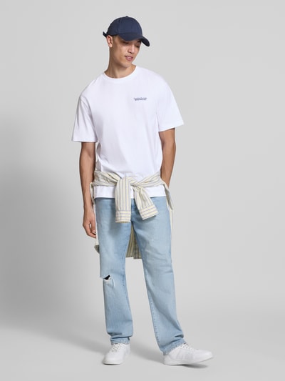 Männermodel trägt weißes Relaxed Fit T-Shirt aus reiner Baumwolle Modell 'FRED DU MARTIN' von Only & Sons mit Motiv-Print, unifarben, Feinripp, Rundhals, kurzarm, Ganzkörperansicht von vorne.