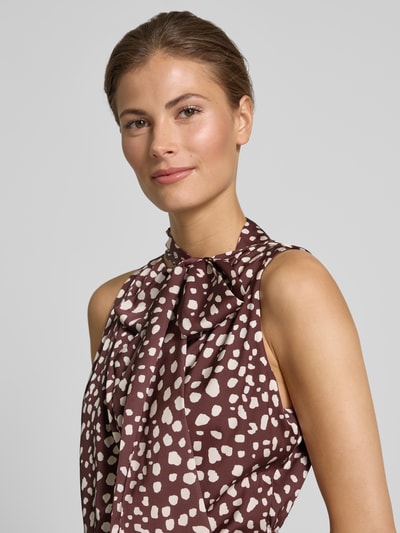 Vrouwenmodel draagt 'Midikleid mit Stehkragen' van Rinascimento in bruin met witte vlekken, elastische stofmix, taillering, mouwloos ontwerp, opstaandekraag, close-up bovenlichaam.