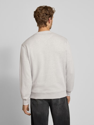 Männermodel trägt Regular Fit Sweatshirt aus reiner Baumwolle mit Label-Patch von Scotch & Soda in Hellgrau, Ganzkörperansicht Rückansicht. Kontext: Herren Sweatshirt von Scotch & Soda, reine Baumwolle, Regular Fit, elastische Abschlüsse, Rückenlänge bei Größe M: 70 cm, Ärmellänge bei Größe M: 66 cm.