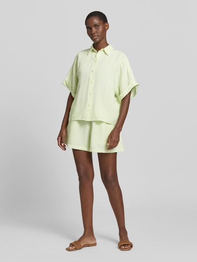 Frauenmodel trägt Relaxed Fit Shorts aus Leinen-Viskose-Mix Modell 'TALLAN' von BOSS Orange, helles Unifarben, elastischer Bund, Ganzkörperansicht von vorne.