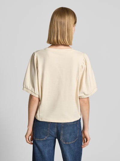 Frauenmodel trägt Relaxed Fit Sweatshirt mit Rundhalsausschnitt Modell 'Aurati' von Drykorn aus elastischem Baumwoll-Mix in Creme mit Halbarm und elastischen Ärmelabschlüssen, Ganzkörperansicht Rückansicht.