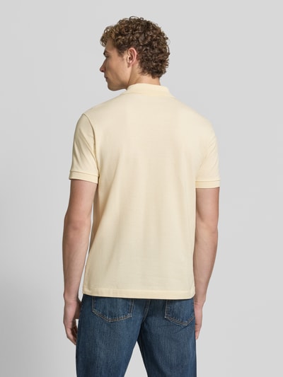 Männermodel trägt Regular Fit Poloshirt aus reiner Baumwolle von Lacoste in Hellgelb, glatte Textur, Herren Poloshirt, Ganzkörperansicht Rückansicht