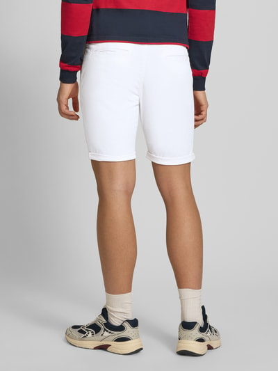 Męski model nosi Regular Fit Shorts mit Eingrifftaschen Modell 'BOWIE' od Jack & Jones, biały bawełniano-elastanowy krój regular fit, tylna perspektywa całej sylwetki, Szerokość w rozmiarze M: 43 cm, długość wewnętrzna nogawki: 26 cm.