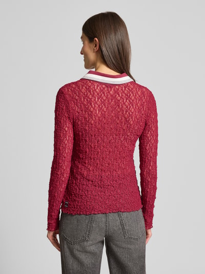 Frauenmodel trägt Slim Fit Longsleeve im semitransparenten Design von Marc Cain in Dunkelrot mit Polokragen, elastischem Baumwoll-Mix, Spitzendetails, Rückenlänge 60 cm, Ganzkörperansicht Rückansicht.