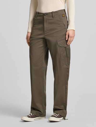 Kobiece model prezentuje spodnie cargo Loose Fit Cargohose aus Baumwoll-Mix od G-Star Raw, mieszanka bawełny i elastanu, kolor oliwkowy, wpuszczane kieszenie, kieszeń cargo, szlufki na pasek, zakończenia nogawek: z troczkami, zapięcie na guzik i zamek błyskawiczny, szerokość w rozmiarze 27: 40 cm, długość wewnętrzna nogawki w rozmiarze 27: 81 cm; widok całej sylwetki z przodu.