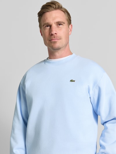 Męski model nosi Regular Fit Sweatshirt aus Baumwoll-Mix od Lacoste, jasnoniebieska bluza, gładka faktura, Nahaufnahme Oberkörper.