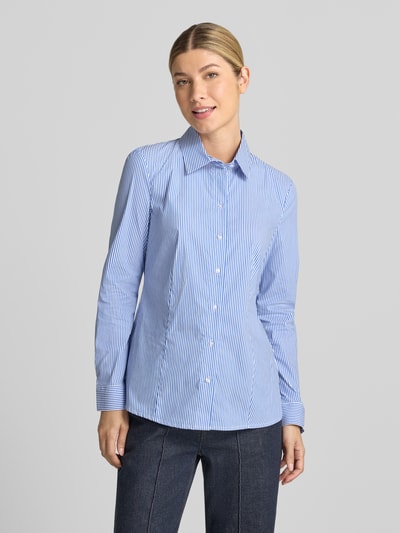 Frauenmodel trägt Hemdbluse aus Baumwoll-Mix von Christian Berg Woman mit feinen blauen und weißen Streifen, taillierte Passform, Langarm, 1-Knopf-Manschetten, Nahaufnahme Oberkörper. Rückenlänge Größe 36: 65 cm, Ärmellänge: 61 cm, Baumwoll-Mix mit Stretch-Anteil.