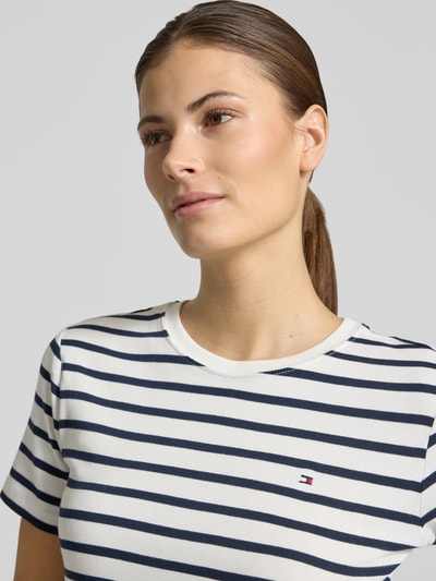 Frauenmodel trägt Slim Fit T-Shirt aus reiner Baumwolle von Tommy Hilfiger, unifarben gestreiftes Jersey mit Logo-Stitching, Nahaufnahme Oberkörper.