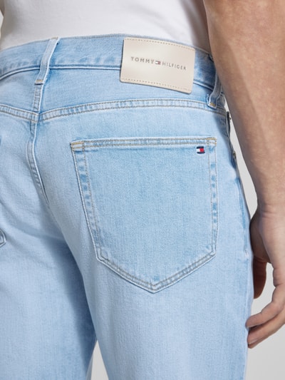 Männermodel trägt Slim Straight Fit Jeans aus Baumwoll-Mix von Tommy Hilfiger in hellblau mit Label Patch, Nahaufnahme Rückansicht.