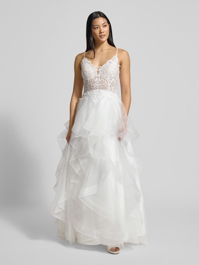 Modelka kobieca nosi Brautkleid mit Details aus Spitze od LUXUAR FASHION, białe warstwowe, koronka, materiał wytrzymały, krój taliowany, widok z przodu, cała sylwetka.