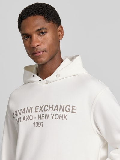 Mannelijk model draagt Hoodie met Label-Print van Armani Exchange in puur katoen, los model, labelprint, capuchon, kangoeroezak, elastische boordjes, ruglengte bij maat M 63 cm, mouwlengte bij maat M 64 cm, Nahaufnahme Oberkörper.