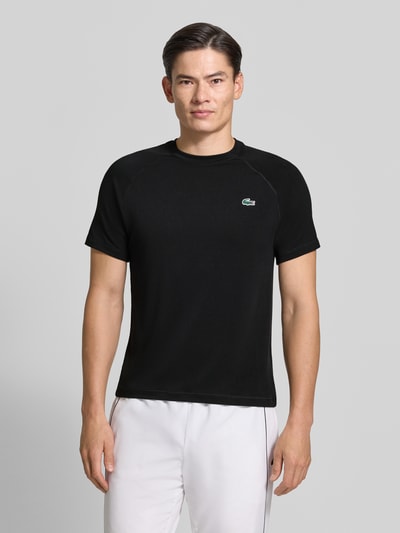 Männermodel trägt schwarzes Regular Fit Sport-T-Shirt mit Logo-Detail von Lacoste, Herren Sport-T-Shirt von Lacoste Sport, Ganzkörperansicht von vorne