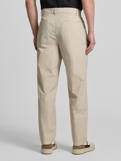 Männermodel trägt Straight Fit Chino aus Baumwoll-Mix von BOSS Orange in Beige, glatte Textur, Ganzkörperansicht Rückansicht.