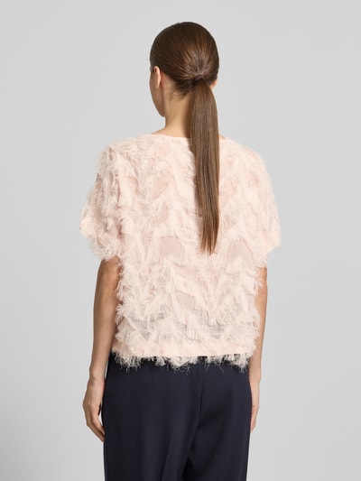 Modelka nosi Boxy Fit Blusenshirt mit Fransen-Design Modell 'MYLINE' von Selected Femme, jasnoróżowy, strukturalny, lekko przezroczysty, krótki rękaw, okrągły dekolt, tkanina chiffon, widoczne frędzle, widok całej sylwetki z tyłu