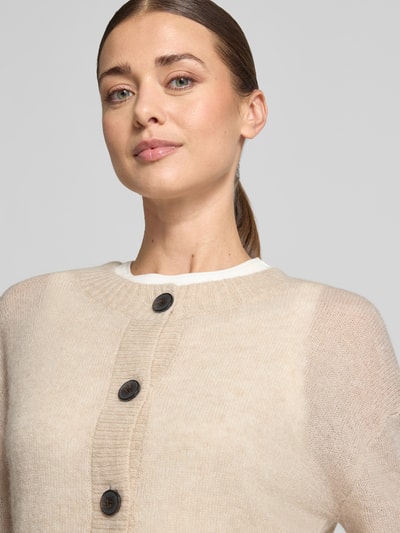 Frauenmodel trägt Strickjacke mit Woll-Anteil von COMMA in Beige, gerippter Rundhalsausschnitt, Nahaufnahme Oberkörper, Material-Mix