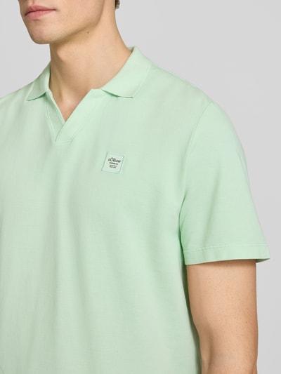 Männermodel trägt Regular Fit Poloshirt aus reiner Baumwolle von s.Oliver RED LABEL, hellgrün, unifarben, Nahaufnahme Oberkörper.