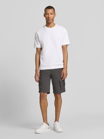 Männermodel trägt Bermudas mit Pattentaschen und Label-Stitchings von PME Legend in Dunkelgrau mit Straight Fit und seitlichen Eingrifftaschen, Knopf-Reißverschluss, Motiv- und Label-Stitchings, Label-Details, Ganzkörperansicht von vorne.