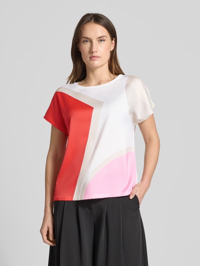 Frauenmodel trägt Regular Fit T-Shirt mit Allover-Muster von s.Oliver BLACK LABEL in Rot, Weiß und Rosa mit abstraktem Print, Nahaufnahme Oberkörper.