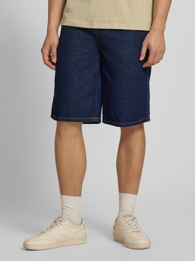 Mannenmodel draagt Loose Fit Bermudas met steekzakken van Dickies, denim in donkerblauw, puur katoen, loose fit, binnenbeenlengte 32 cm, bandwijdte 42 cm, ganzekörperaanzicht van voren.
