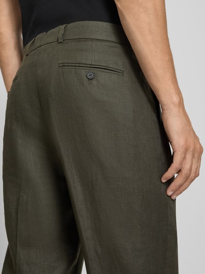 Männermodel trägt Regular Fit Anzughose aus reinem Leinen Modell 'BAILEY' von SELECTED HOMME in Olivgrün, Nahaufnahme Rückansicht.