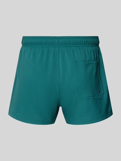 Produktfoto, Badehose mit Seitentaschen und Klettverschlusstasche hinten von PUMA in dunklem Türkis, Regular-Fit, elastischer Bund, glatte Textur.