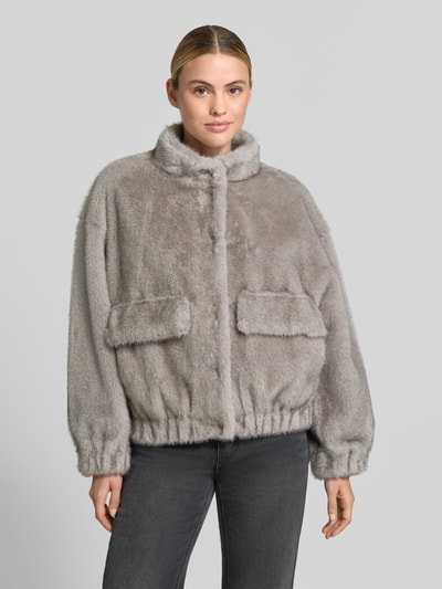 Kobiece modelka nosi Regular Fit kurtkę ze sztucznego futra Model 'GIACCONE' od Liu Jo White, szary kolor, kieszenie z patką, stójka, elastyczne wykończenia, długość tyłu w rozmiarze 36: 59 cm, szerokość ramion w rozmiarze 36: 56 cm, szerokość w rozmiarze 36: 60 cm, długość rękawów w rozmiarze 36: 50 cm, widok całej sylwetki z przodu.
