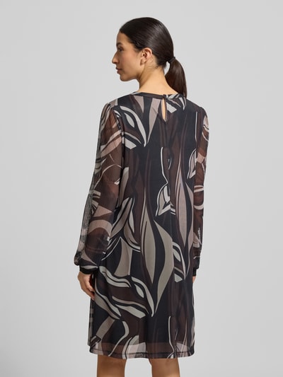 Frauenmodel trägt Knielanges Kleid mit Rundhalsausschnitt von Betty Barclay, abstraktes Muster, tailliert, knielang, blickdicht, Material-Mix, Ganzkörperansicht Rückansicht.
