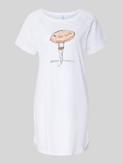 Frauenmodel trägt Oversized Nachthemd mit Motiv-Print Modell 'Sommerliebe' von LOUIS & LOUISA aus reiner Baumwolle, weiß mit Rundhalsausschnitt, kurzen Ärmeln mit Aufschlag, glatte Textur, im Vordergrund zentrierter Print, Ganzkörperansicht von vorne.