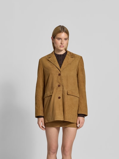 Frauenmodel trägt Blazer aus echtem Ziegenvelours von ROTATE in Braun mit Reverskragen und Pattentaschen, Ganzkörperansicht von vorne.