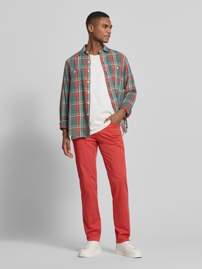 Męski model nosi Slim Fit Stoffhose mit Lyocell-Anteil Modell 'Cadiz' od Brax, czerwony kolor, krój slim fit, bawełniana mieszanka z lyocellem, fason 5-kieszeniowy, zapięcie na guzik i zamek, szerokość w rozmiarze 32/32: 107 cm, długość nogawki wewnętrznej w rozmiarze 32/32: 81 cm, widok całej sylwetki z przodu.