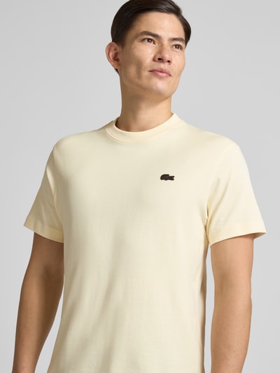 Męski model nosi Regular Fit T-Shirt aus reiner Baumwolle Modell 'LOURD' von Lacoste w jednolitym kolorze, logo na piersi, krótki rękaw, bawełna, zbliżenie górnej części ciała z przodu.