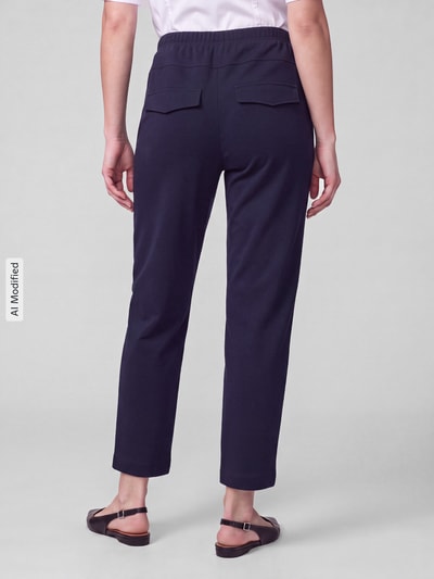 Frauenmodel trägt Barrel Leg Hose mit angedeuteten Taschen Modell 'Rachell' von Stehmann, jednokolorowy efekt, krój barrel fit, średni stan, elastyczny pas, wpuszczane kieszenie boczne, wykończenie materiału: dzianina dresowa, Ganzkörperansicht Rückansicht, KI-modifiziertes Bild