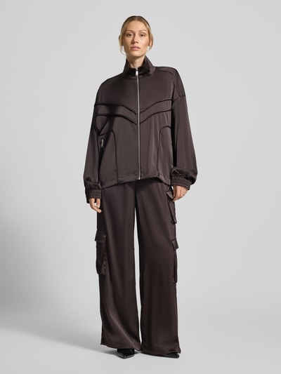 Frauenmodel trägt Relaxed Fit Jacke mit Stehkragen Modell 'Darzi' von Gestuz in Dunkelbraun, glatte Textur, Ganzkörperansicht von vorne. Rückenlänge 62 cm, Schulterbreite 44 cm, Brustweite 65 cm, Ärmellänge 56 cm, elastischer Material-Mix.