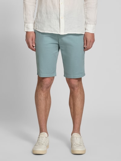 Männermodel trägt Slim Fit Chinoshorts aus reiner Baumwolle von Tom Tailor, unifarben, seitliche und Paspeltaschen, Ganzkörperansicht von vorne.
