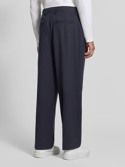 Männermodel trägt Stoffhose mit Bügelfalte Modell 'GRANT' von Casual Friday, dunkelblau mit feinen Streifen, Ganzkörperansicht Rückansicht. Material-Mix mit Viskose-Anteil, Straight Fit, Knopf- und Reißverschluss, französische Eingrifftaschen, Gesäßleistentaschen, Bundweite 43 cm, Innenbeinlänge 75 cm.