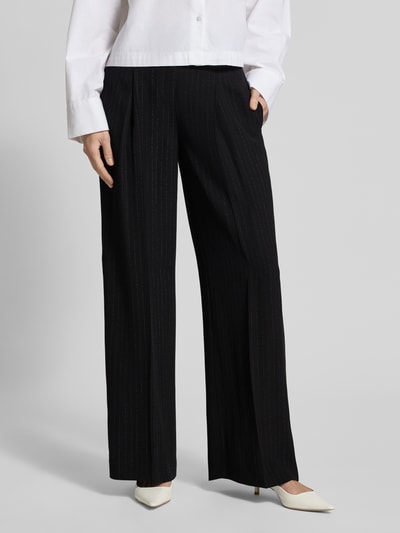Frauenmodel trägt Weite Hose aus reiner Viskose Modell 'TIANA4' von BOSS mit Nadelstreifen, Allover-Muster, seitlichen Taschen, Nahaufnahme Unterkörper.