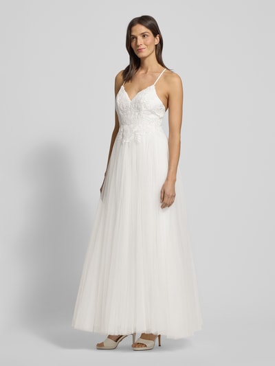 Modelka kobieca nosi Brautkleid mit floralen Stickereien od Mascara, biały kolor, spódnica rozkloszowana, koronka, widok całej sylwetki z przodu.