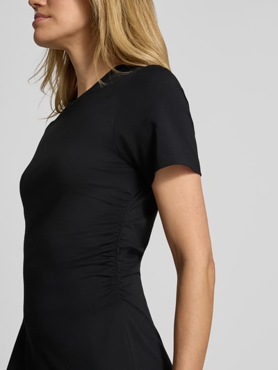 Vrouwenmodel draagt Tailliertes Jersey-Kleid aus Baumwoll-Mix van s.Oliver RED LABEL, zwart, getailleerd, korte mouwen, jersey katoenmix, detailopname zijkant.