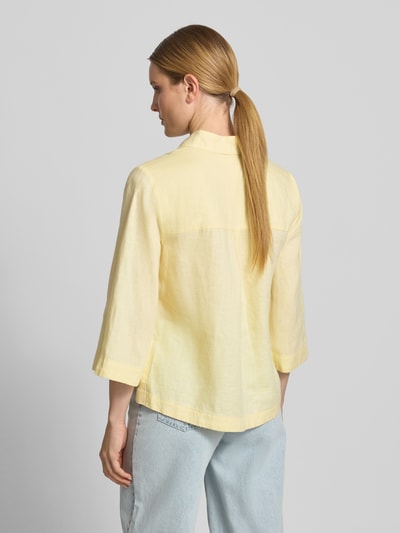 Frauenmodel trägt Relaxed Fit Leinenbluse mit 3/4-Arm von Christian Berg Woman in zartem Gelb, reine Leinen, Hemdblusenkragen, Knopfleiste, Rückenlänge 65 cm, Ärmellänge 48 cm, glatte Struktur, lockere Form, Ganzkörperansicht Rückansicht.