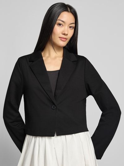 Frauenmodel trägt Regular Fit Blazer mit Viskose-Anteil Modell 'BYRIZETTA' von b.young, schwarze Farbe, glatte Struktur, Ganzkörperansicht von vorne. Material-Mix mit Reverskragen, Knopfverschluss, Rückenlänge 46 cm, Brustweite 51 cm, Ärmellänge 61 cm.