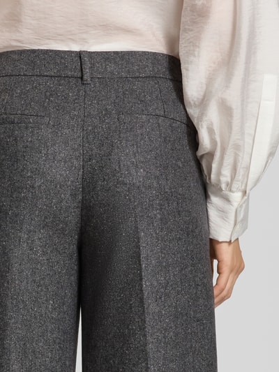 Frauenmodel trägt Straight Fit Hose aus Schurwoll-Mix mit Seiden-Anteil von Marella, graue Textur, Bügelfalten, Nahaufnahme Rückansicht.
