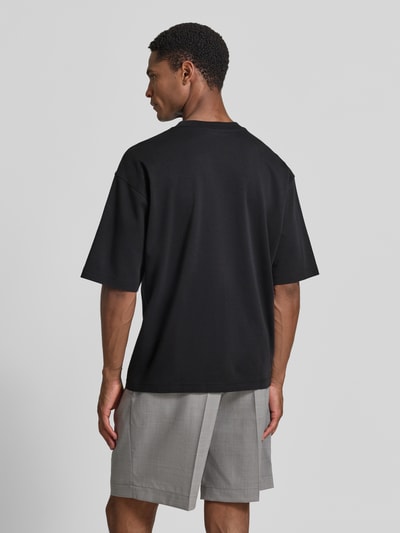 Männermodel trägt Relaxed Fit T-Shirt mit Rundhalsausschnitt von JAKE*S STUDIO MEN in Schwarz aus Reine Baumwolle, Kurzärmelig, Rückenlänge bei Größe M 67 cm, Ganzkörperansicht Rückansicht.