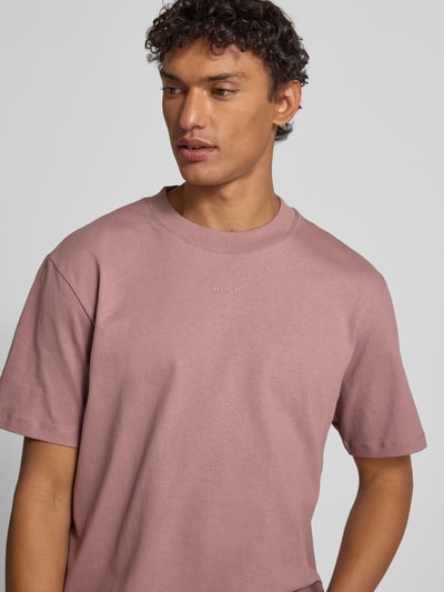Männermodel trägt Regular Fit T-Shirt aus reiner Baumwolle Modell 'DALOLINO' von HUGO, Optik: Unifarben, Label-Schriftzug, Rundhals, Kurzarm, Ganzkörperansicht von vorne.