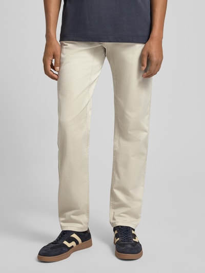 Męski model nosi Regular Fit Chino aus Baumwoll-Mix von s.Oliver RED LABEL w kolorze jasnobeżowym, krój regular fit, bawełniany materiał, 5 kieszeni, guziki i ukryty zamek, łatka z logo, widok na nogi z przodu, zbliżenie dolnej części ciała.